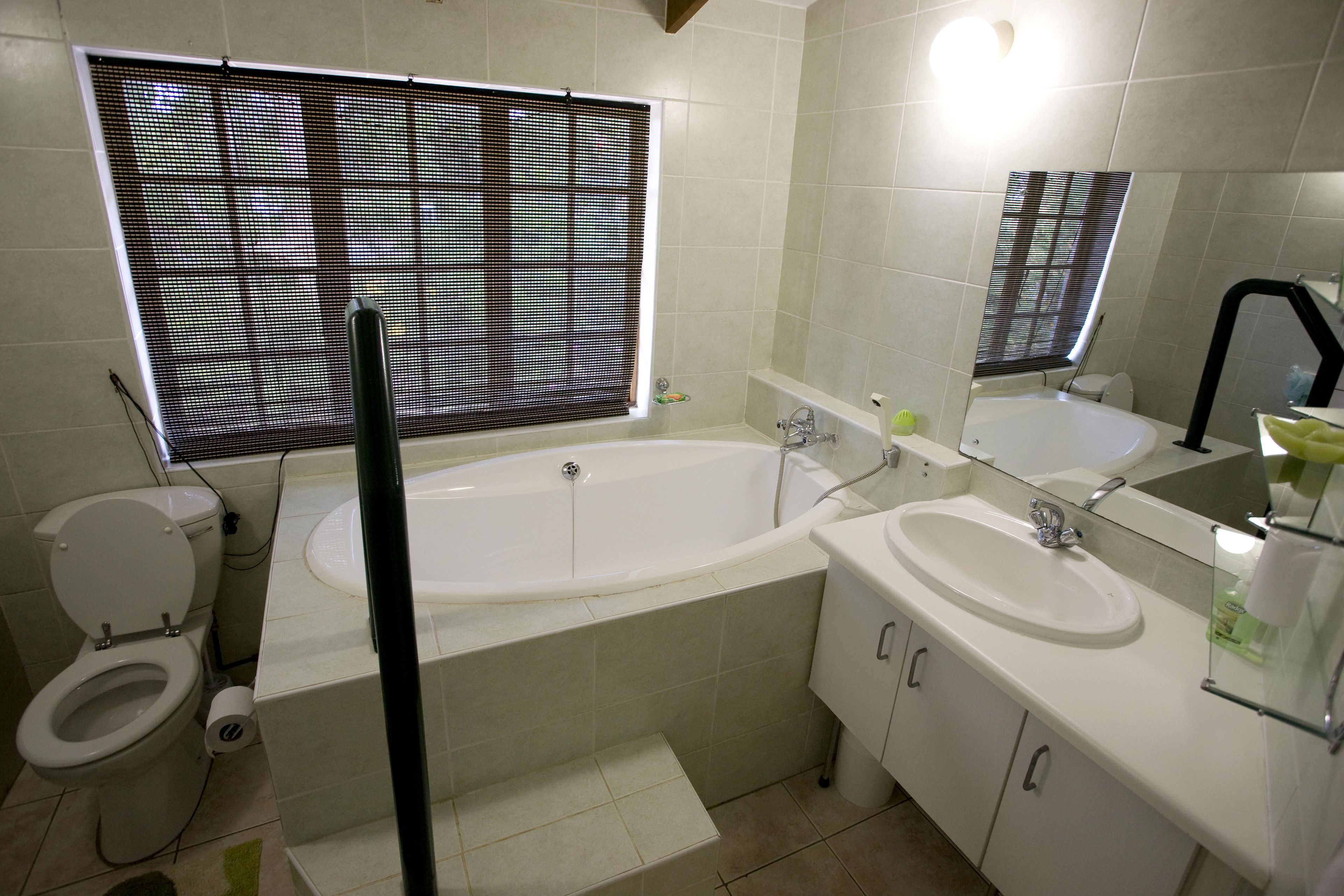 A bathroom with a toilet, bathtub, and two sinks.