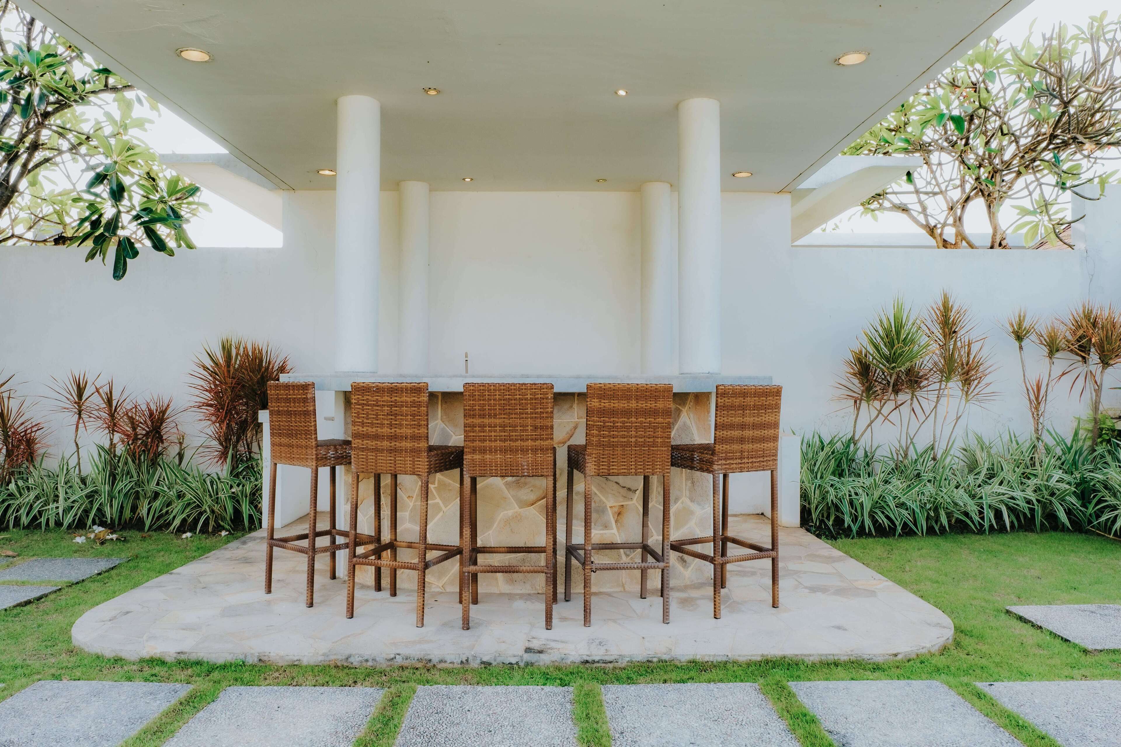 An outdoor bar area with wicker chairs and a central bar.