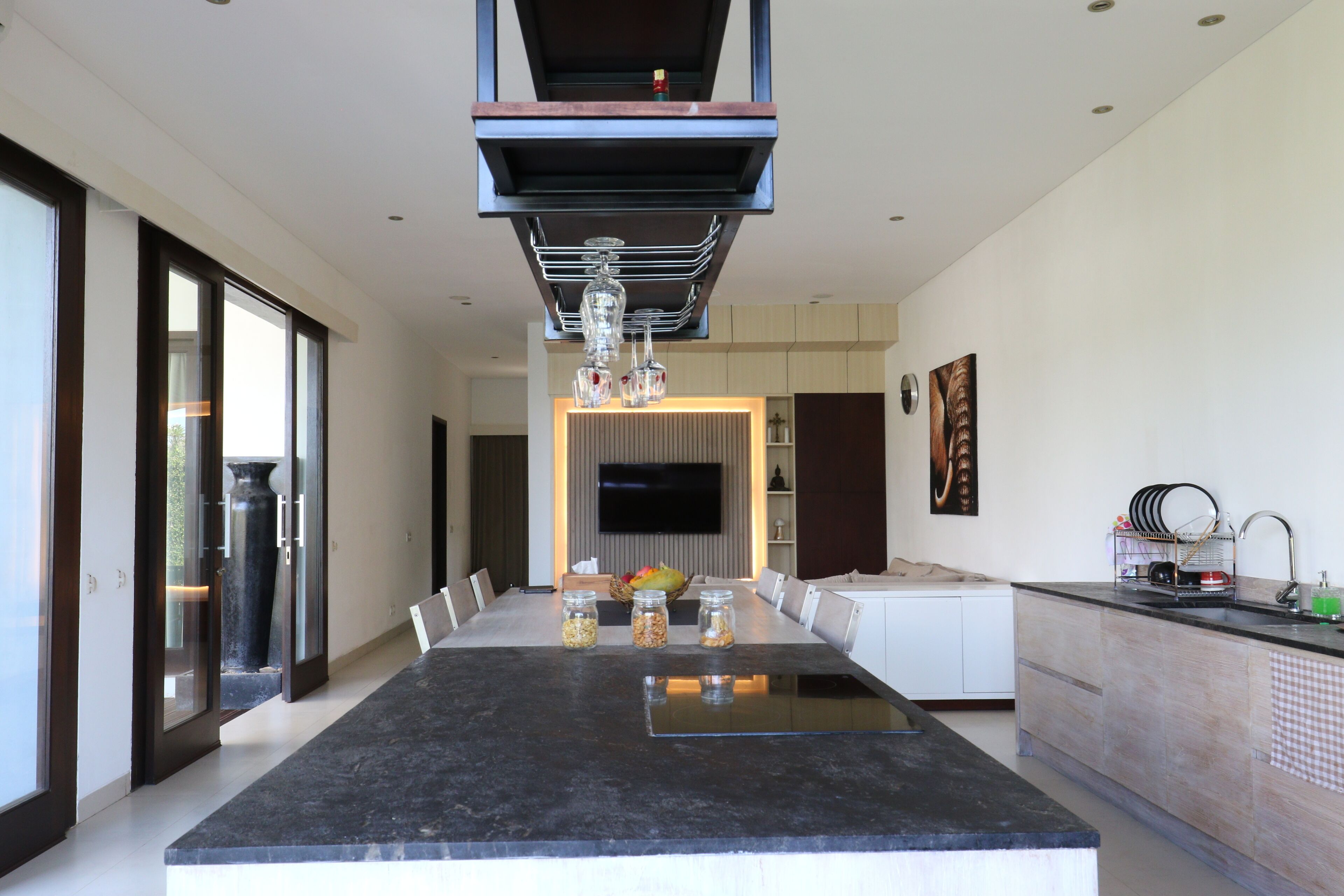 A modern kitchen with a large island, built-in appliances, and a dining area with a long table.