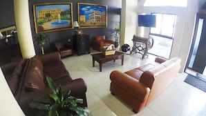 A spacious lobby with leather sofas, a coffee table, potted plants, and artwork on the walls. - Hotel Oriente (Veracruz)