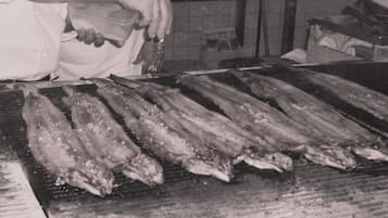 Jemand grillt Fisch auf einem Grill.