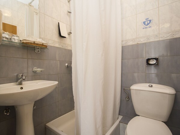 A bathroom with a sink, toilet, and bathtub.