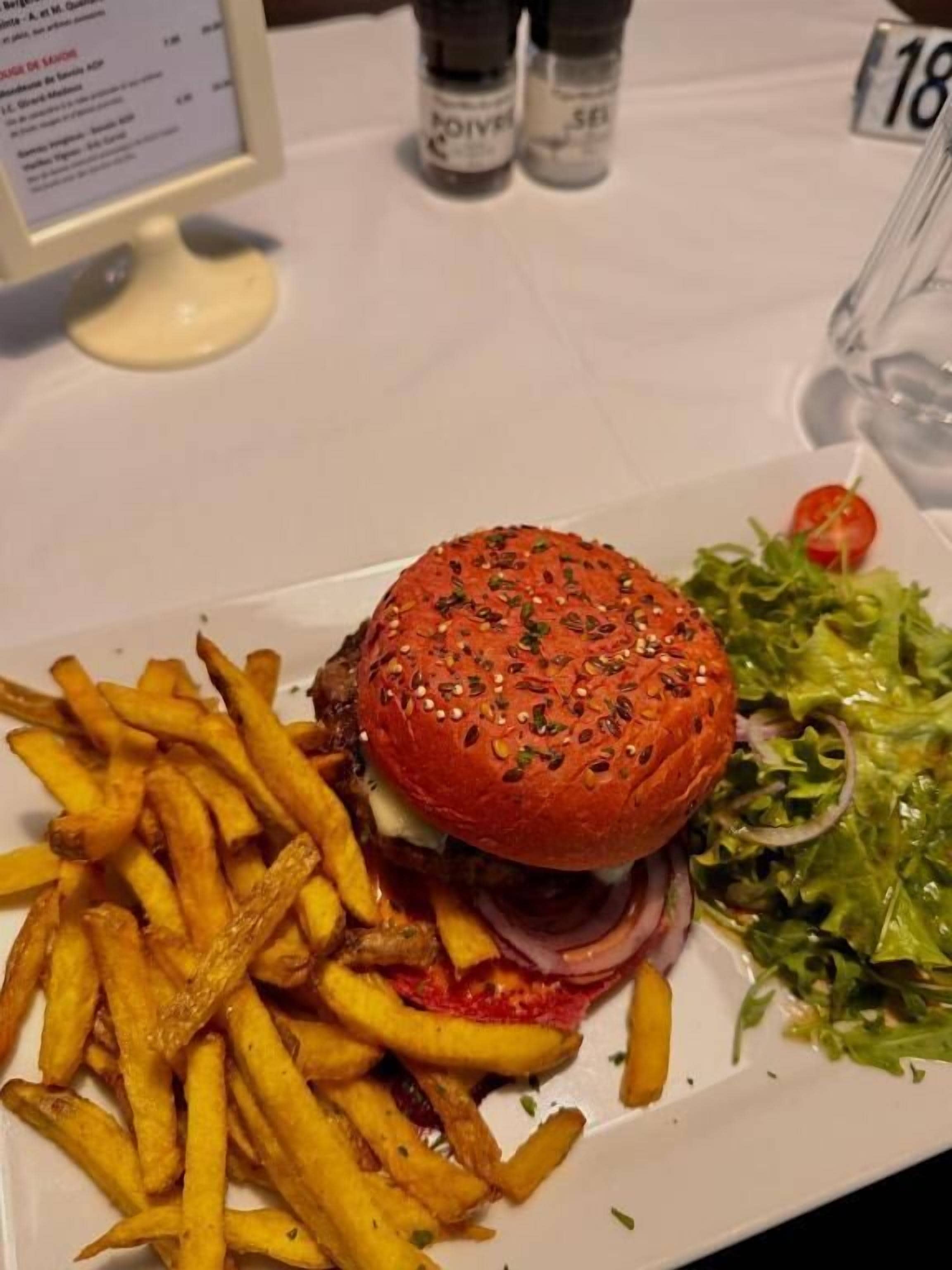 A meal consisting of a burger with a sesame seed bun, fries, and a side salad.
