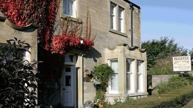 A two-story building with a sign indicating it is a guesthouse. - Bellevue Guest House (Kelso)