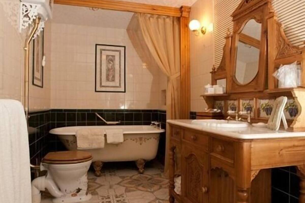 Une salle de bain avec une baignoire, des toilettes, un meuble-lavabo et un miroir.