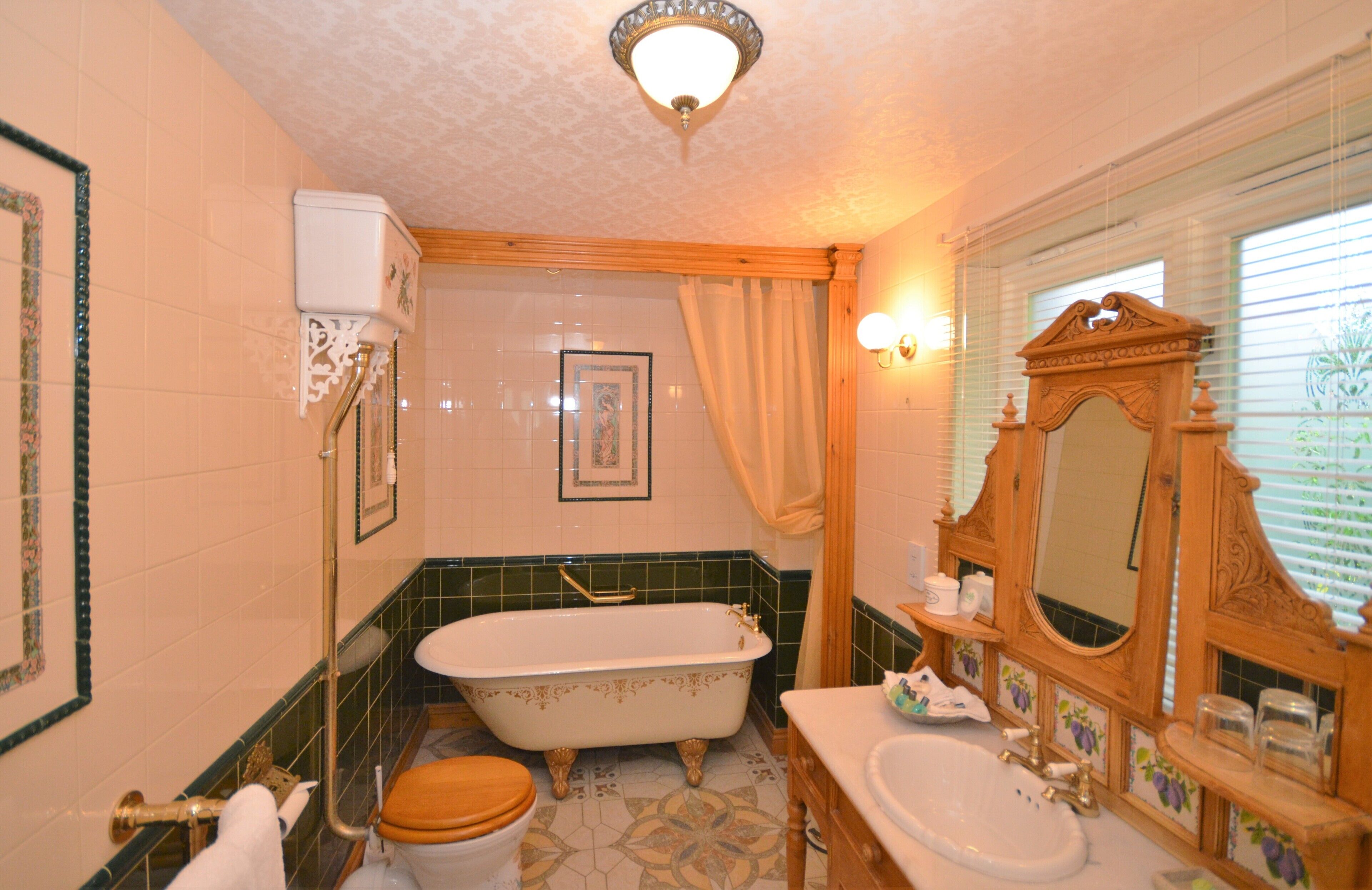 Une salle de bain avec une baignoire sur pieds, des toilettes, un lavabo et un grand miroir.