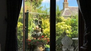 Vista de un jardín con diversas plantas y una fuente decorativa.