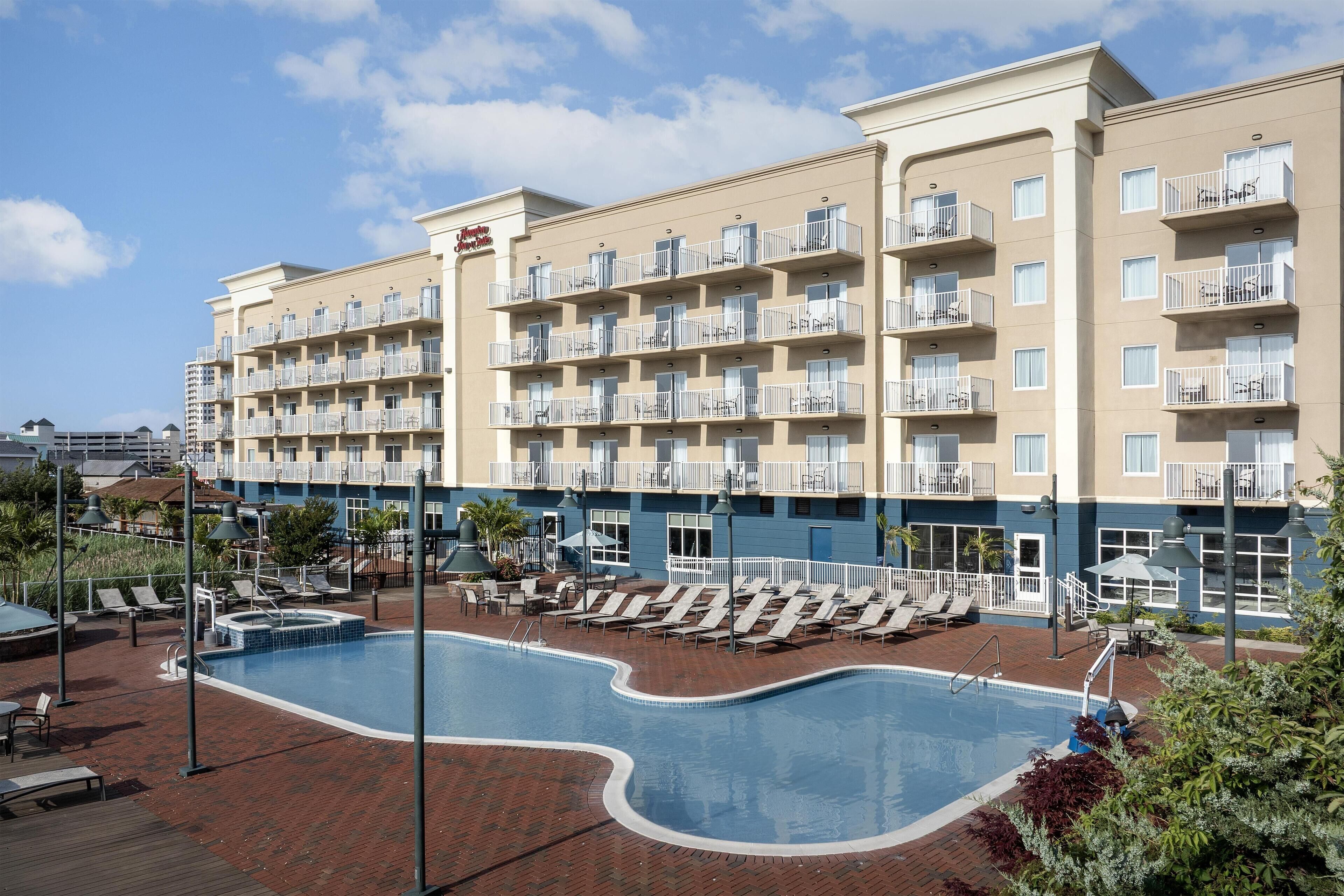 Un hôtel doté d’une piscine, de nombreux balcons et d’espaces de détente en plein air.