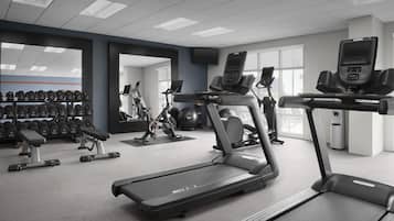 A modern gym with treadmills, dumbbells, and weight machines.