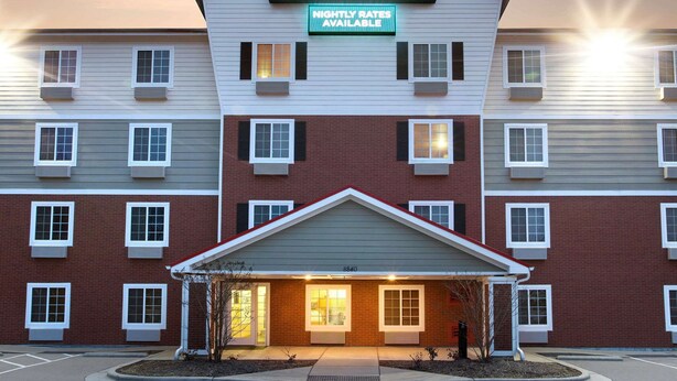A multi-story hotel with a sign indicating "Woodspring Suites" and "Nightly Rates Available." - WoodSpring Suites Raleigh Northeast Wake Forest (Raleigh)
