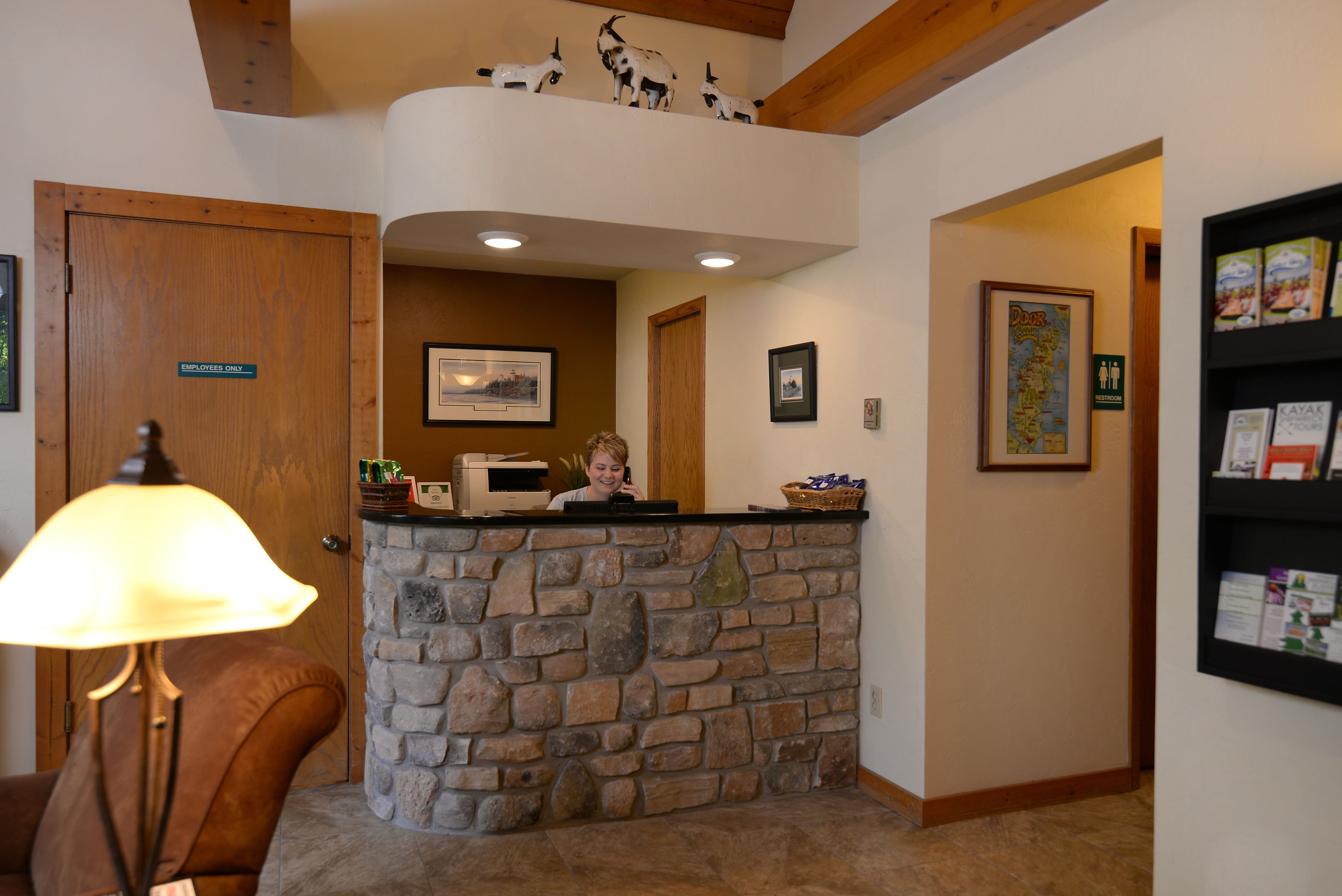 A reception area with a stone counter, a wooden door labeled "Employees Only," and a lamp.
