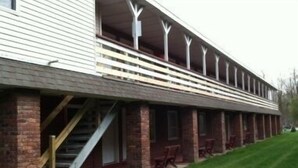 A building with a covered porch, brick columns, and a staircase leading to the entrance. - Waterford Inns on the Hudson (Waterford)
