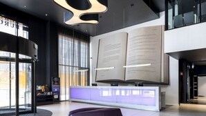 A modern lobby with a large open space, a reception desk, and a seating area. - Eurostars Book Hotel (Munich)