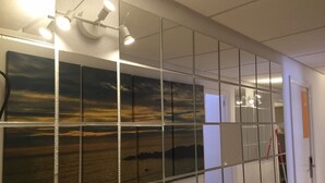 A corridor with a large wall-mounted artwork depicting a sunset over water. - Hostal Los Pinos (Santa Eulalia del Rio)