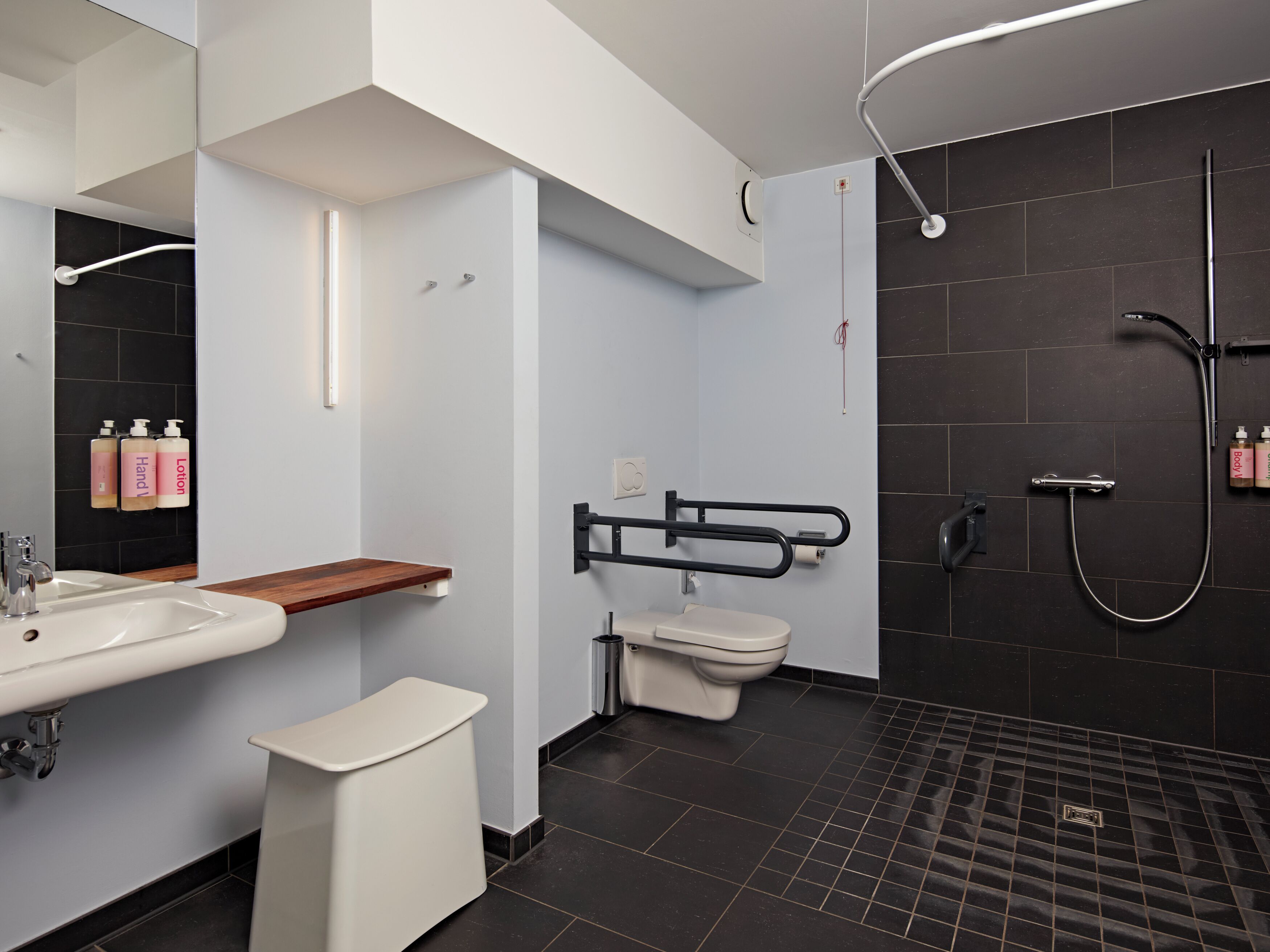 A modern bathroom with a sink, toilet, and shower.