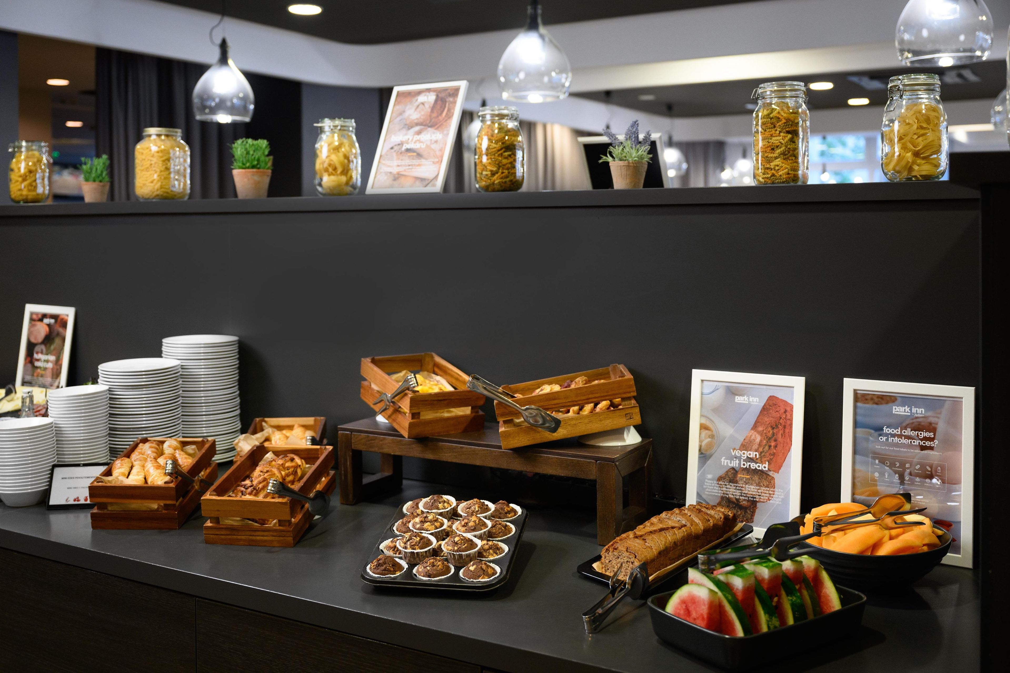 Ein Buffet mit verschiedenen Speisen, darunter Gebäck, Früchte und einer Auswahl an Getränken.