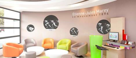 A modern reception area with a curved ceiling, a reception desk, and several seating options.