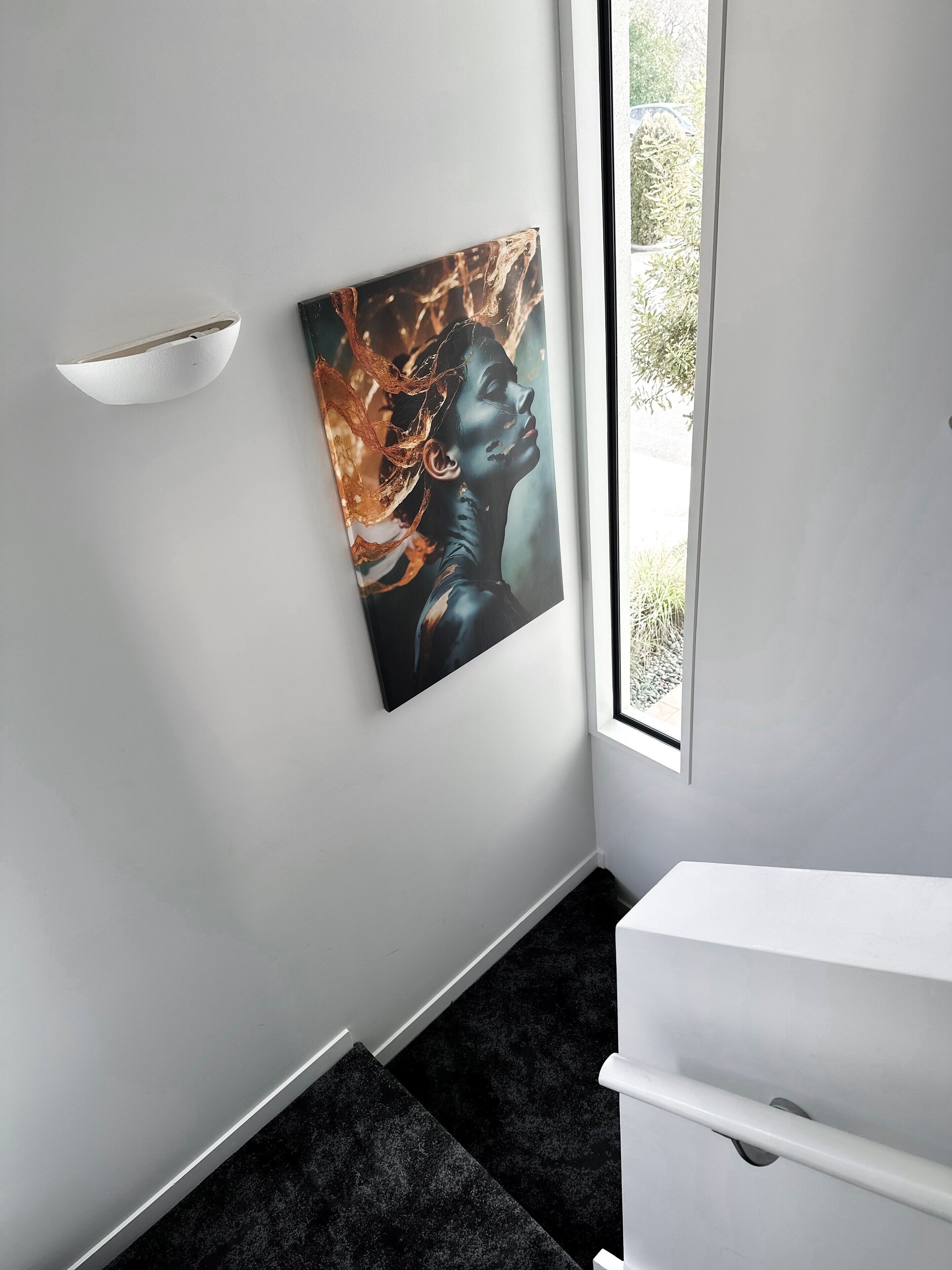 Ein modernes Badezimmer mit einem weißen Waschbecken, einem dunklen Teppichboden und einer wandmontierten Leuchte.