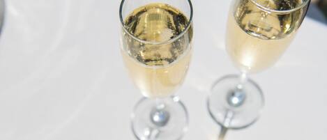 Deux verres de vin blanc sur une table blanche.