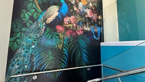 A wall mural with a peacock and floral design. - DeLorenzo's Studio Apartments (Nelson)