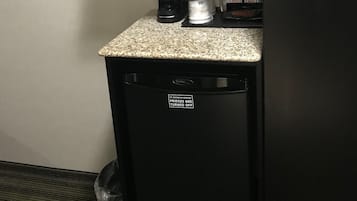 A kitchenette with a microwave, coffee maker, and a refrigerator.
