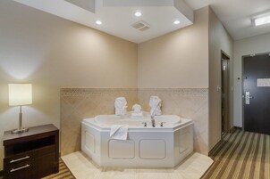 Un baño moderno con una bañera independiente, un tocador con cajones y un perchero para toallas.