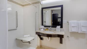 A modern bathroom with a shower, a sink with a mirror, and a towel rack.