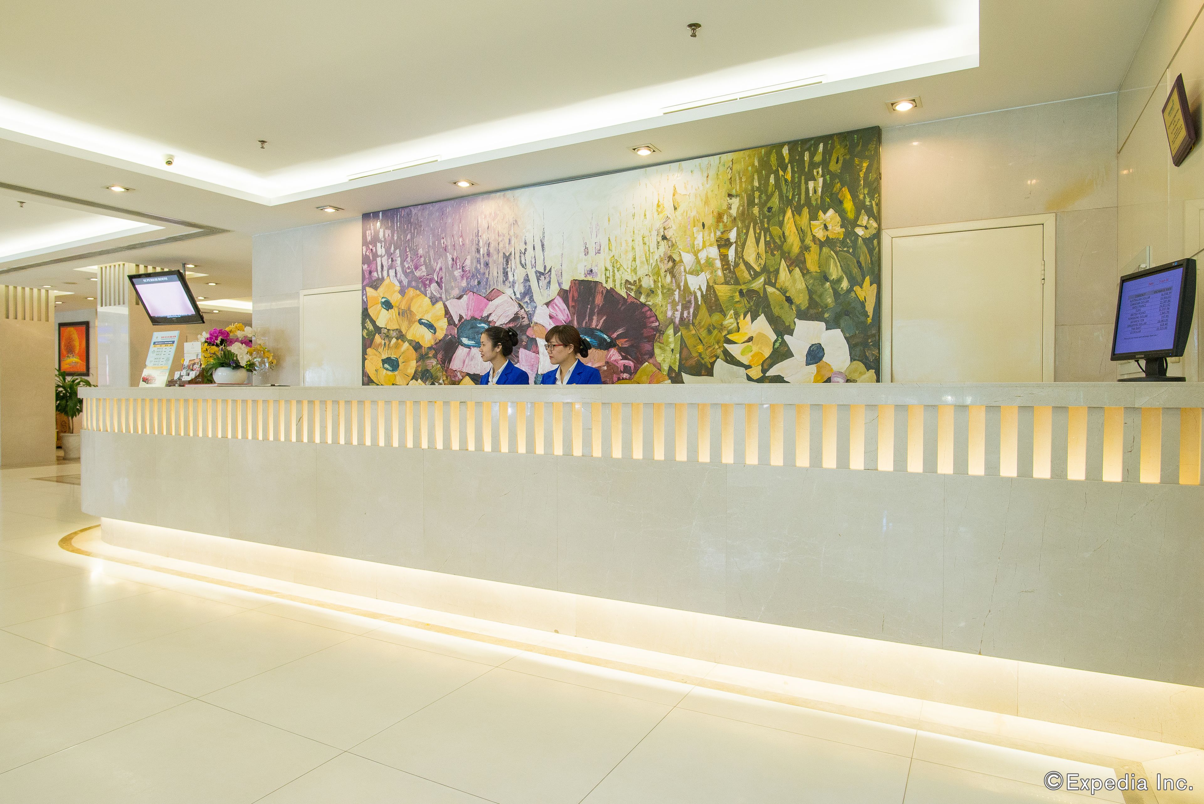 A reception desk with a large floral mural, a digital display, and a reception area with a clean, modern design.
