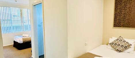 Habitación de hotel con cama, una zona de estar pequeña y vistas a través de una puerta.