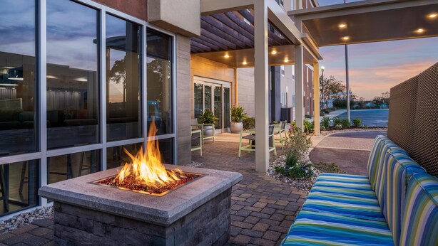 Un espacio al aire libre con zona de estar, chimenea y vistas del exterior del edificio.