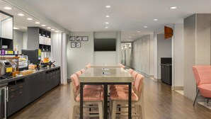 Una cocina moderna con una barra alargada, electrodomésticos integrados y un comedor con mesa y sillas.