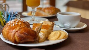 A breakfast setting with croissants, a glass of orange juice, and a cup of coffee on a table. - Hotel da Raffaele (Ischia)