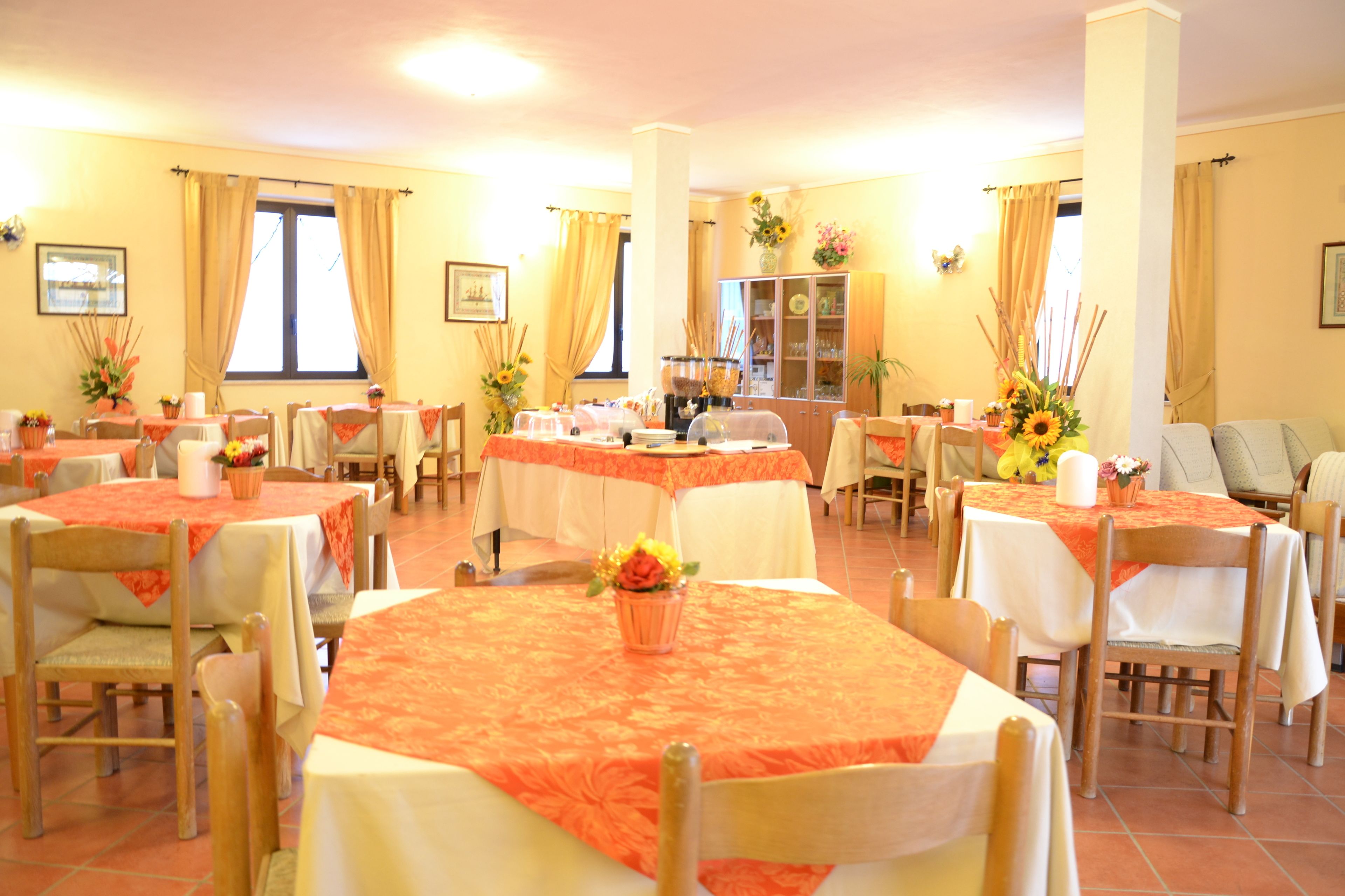 Un espace repas comprenant plusieurs tables, des chaises et un buffet dont les portes sont en verre.