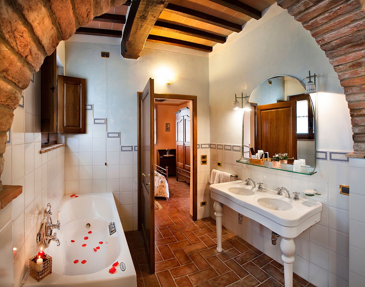 A bathroom with a large bathtub, two sinks, and a mirror.