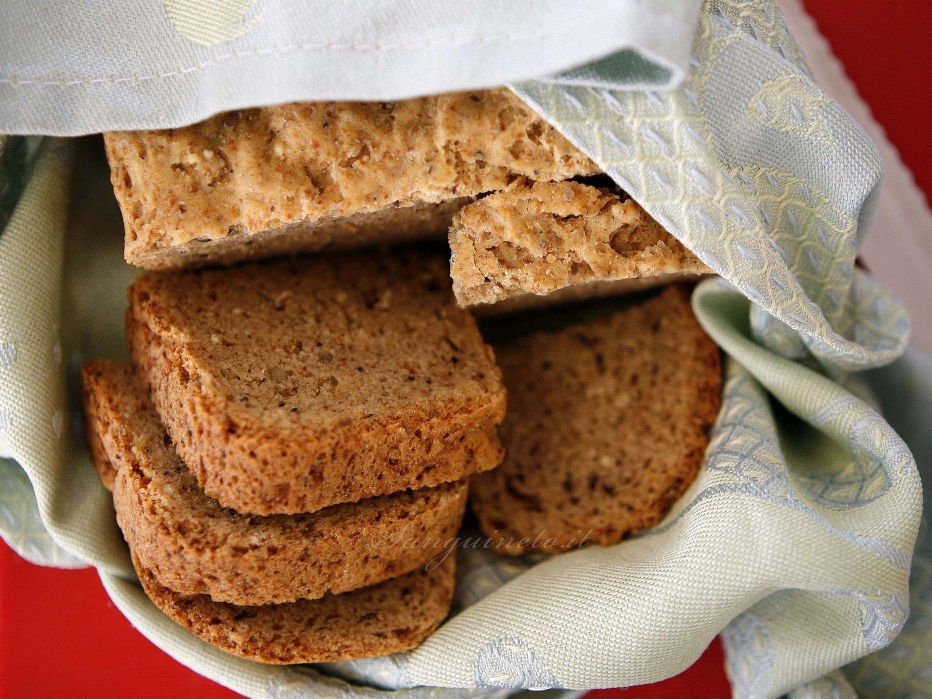 A stack of whole grain crackers in a white cloth with a subtle pattern.