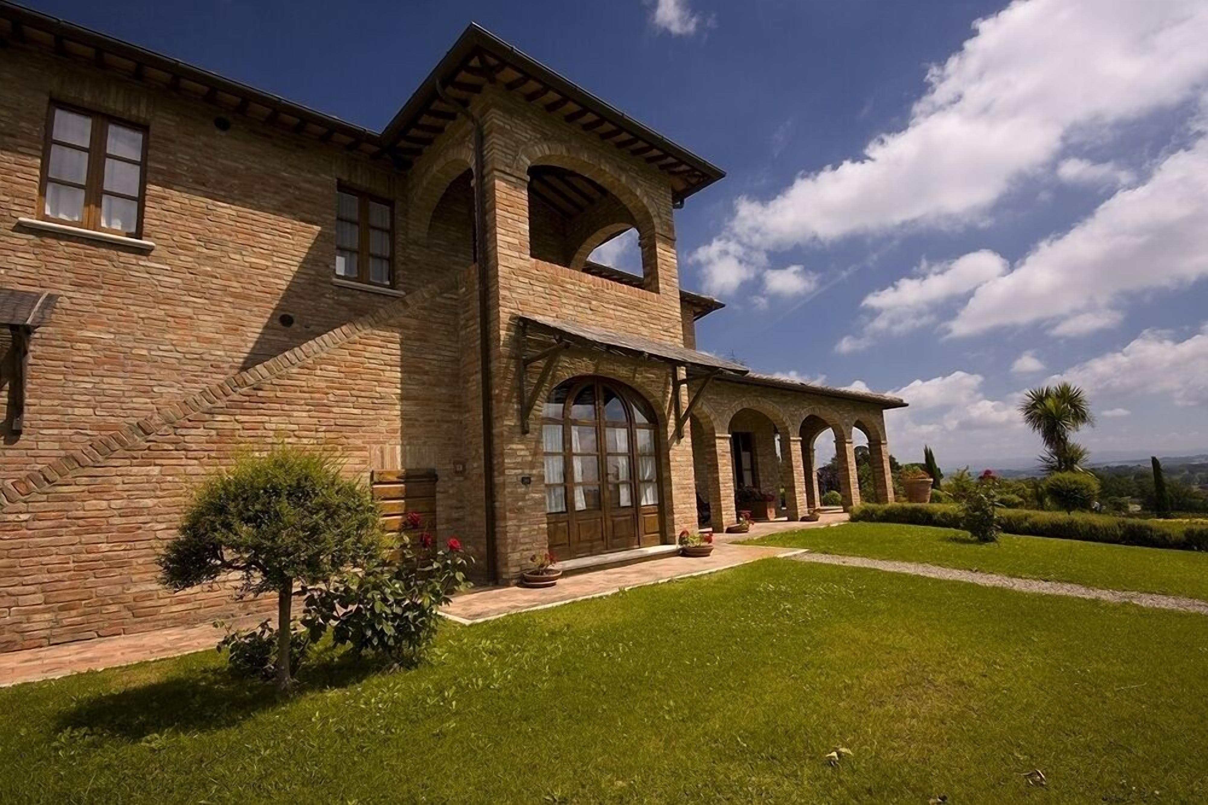 A stone building with a large arched entrance and a covered porch.