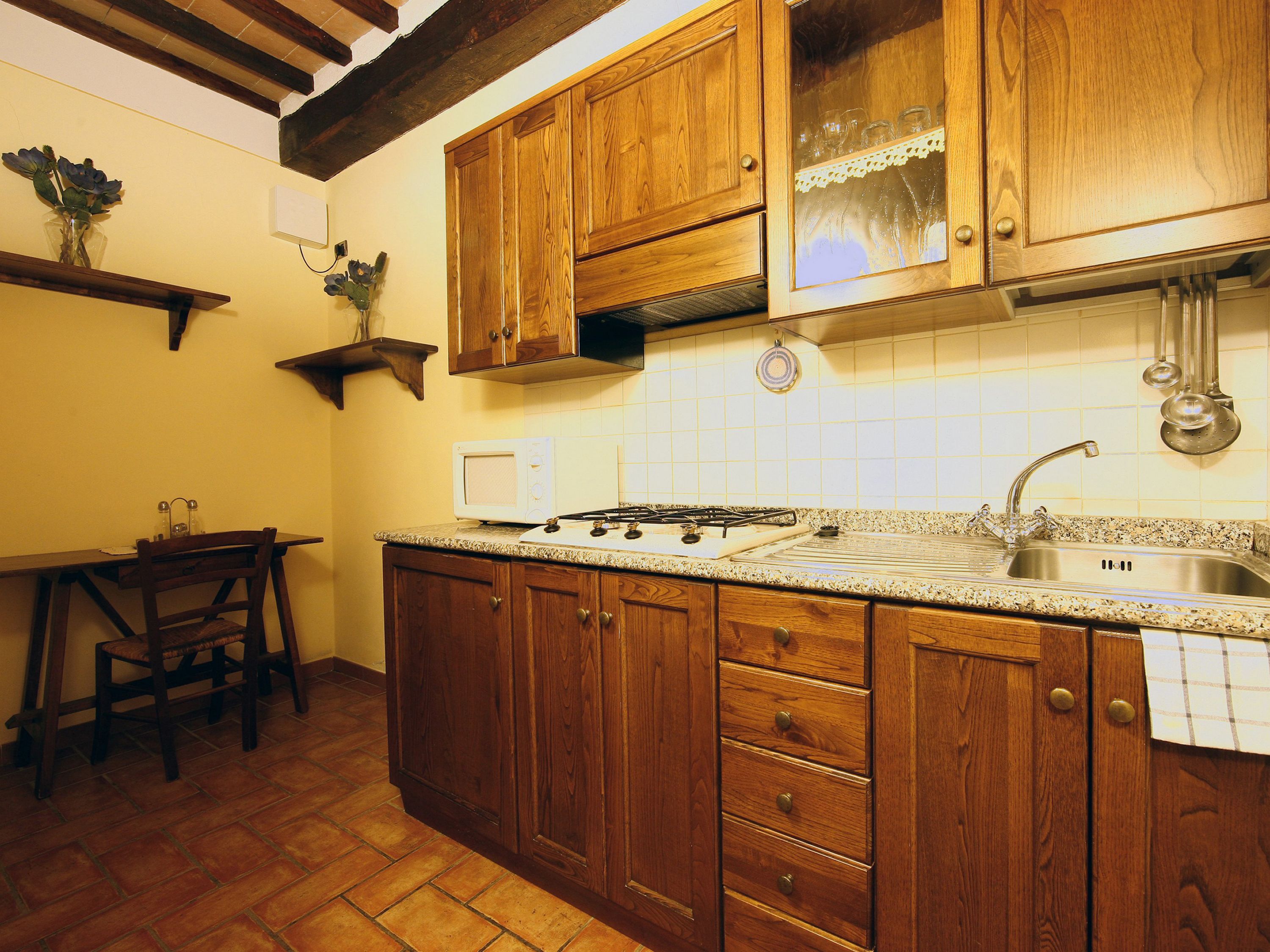 A kitchen with wooden cabinets, a stove, and a sink.