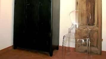 A room with a black cabinet, a wooden door, and a clear plastic chair.