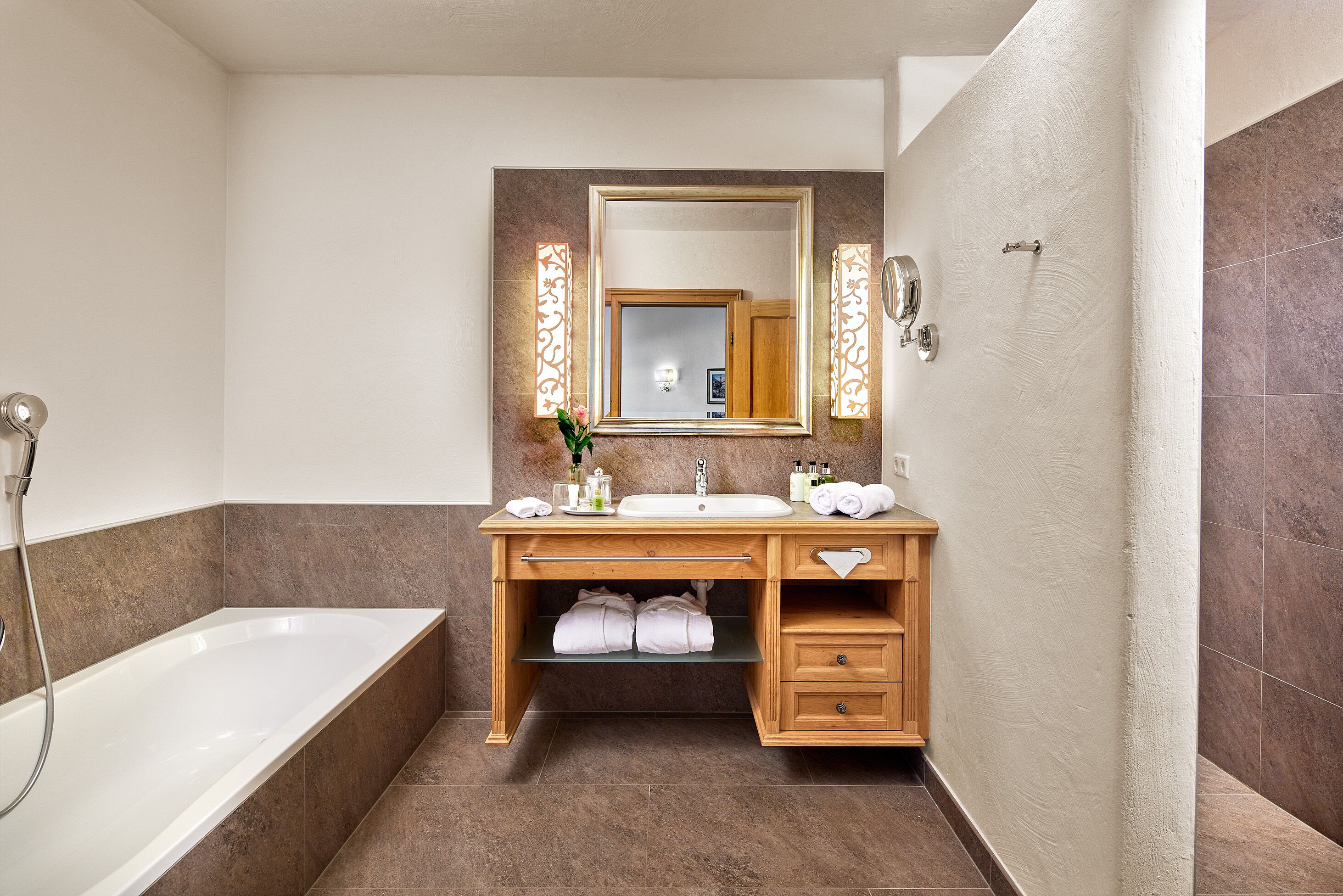 Un baño moderno con bañera, lavamanos y tocador con espejo.