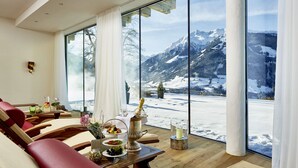 A cozy room with a large window overlooking a snowy mountain landscape.