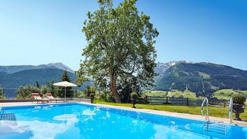 Een buitenzwembad, parasols voor strand/zwembad