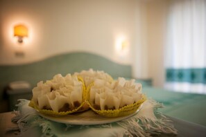 Una cama con cabecera verde y almohada blanca.
