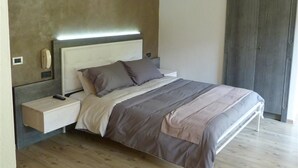 A bedroom with a bed, bedside table, and a wardrobe. - Hotel Al Sole (Auronzo di Cadore)