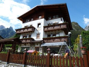 A multi-story hotel with balconies, a restaurant, and a wooden fence. - Hotel Al Sole (Auronzo di Cadore)