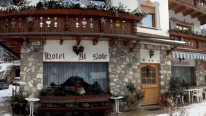 A traditional Alpine-style hotel with a stone facade, wooden balconies, and a restaurant named "Ristorante". - Hotel Al Sole (Auronzo di Cadore)