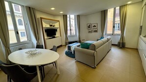 A modern living room with a dining table, sofa, and TV. - Interno 5 (Rome)
