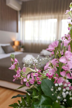 A bedroom with a bed, pillows, and a bedside table.