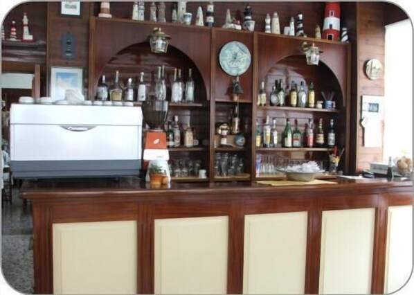 Una zona de bar con un refrigerador, estantes llenos de botellas y un reloj.