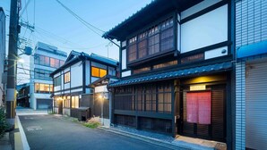 A traditional Japanese street with a narrow alleyway, wooden buildings, and a bicycle lane.