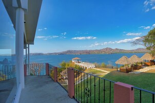 Un balcón con vistas a un lago y montañas.